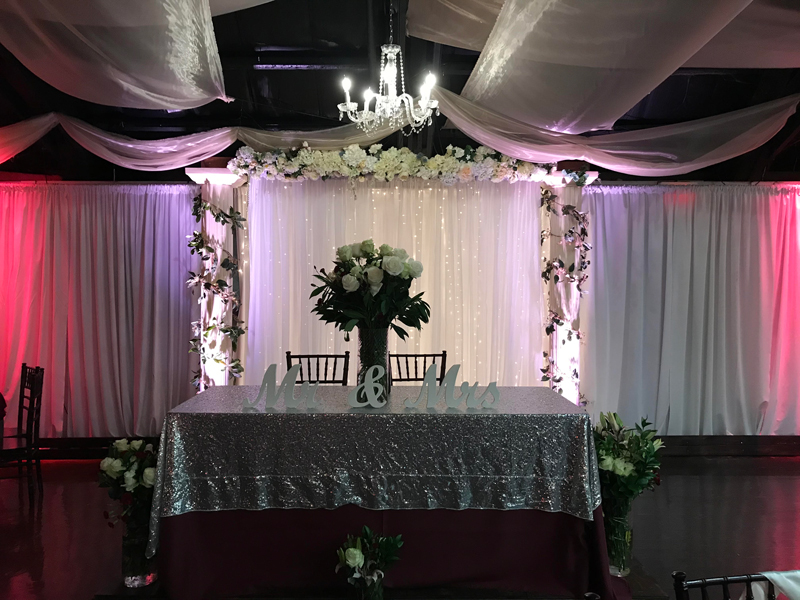 Head Table Background with Columns & Twinkle Lights. Table is on a Stage.