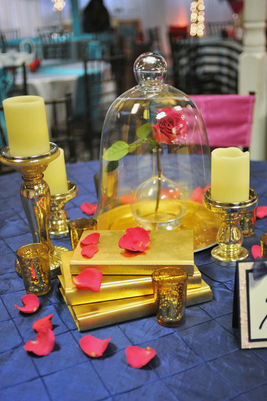 Romantic centerpiece with red roses under a glass dome, inspired by a classic fairytale