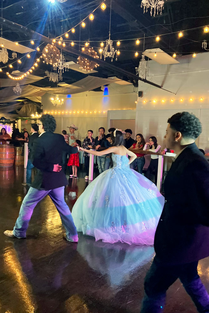Classic ballroom dance floor entry beneath glowing chandeliers in a fairytale-inspired venue