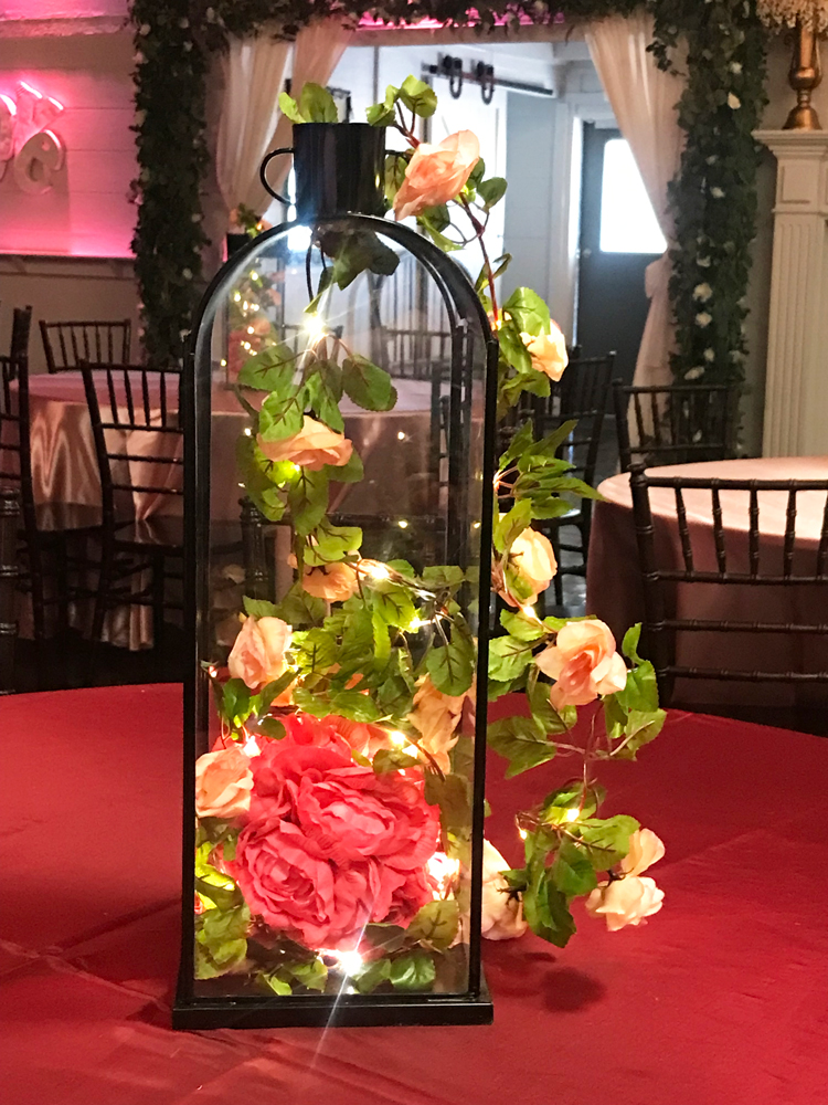 Classic lantern centerpiece with red roses under a glass dome, inspired by a classic fairytale