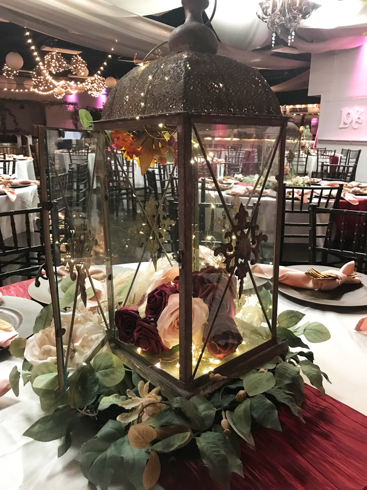Fairytale-inspired rustic lantern centerpiece featuring a romantic floral design