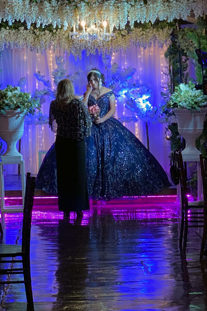 Mother/daughter sharing a memorable moment under soft blue reception lighting