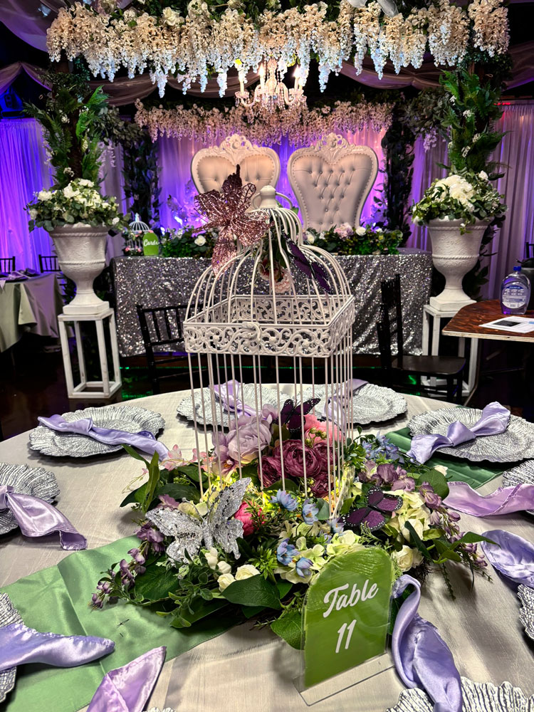 Whimsical quinceañera centerpiece design with butterfly elements, pastel accents, and accent lighting