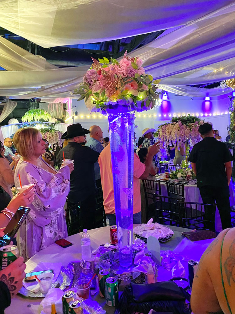 Whimsical tall cylinder vase centerpiece design with floating butterfly elements, floral accents, and accent lighting