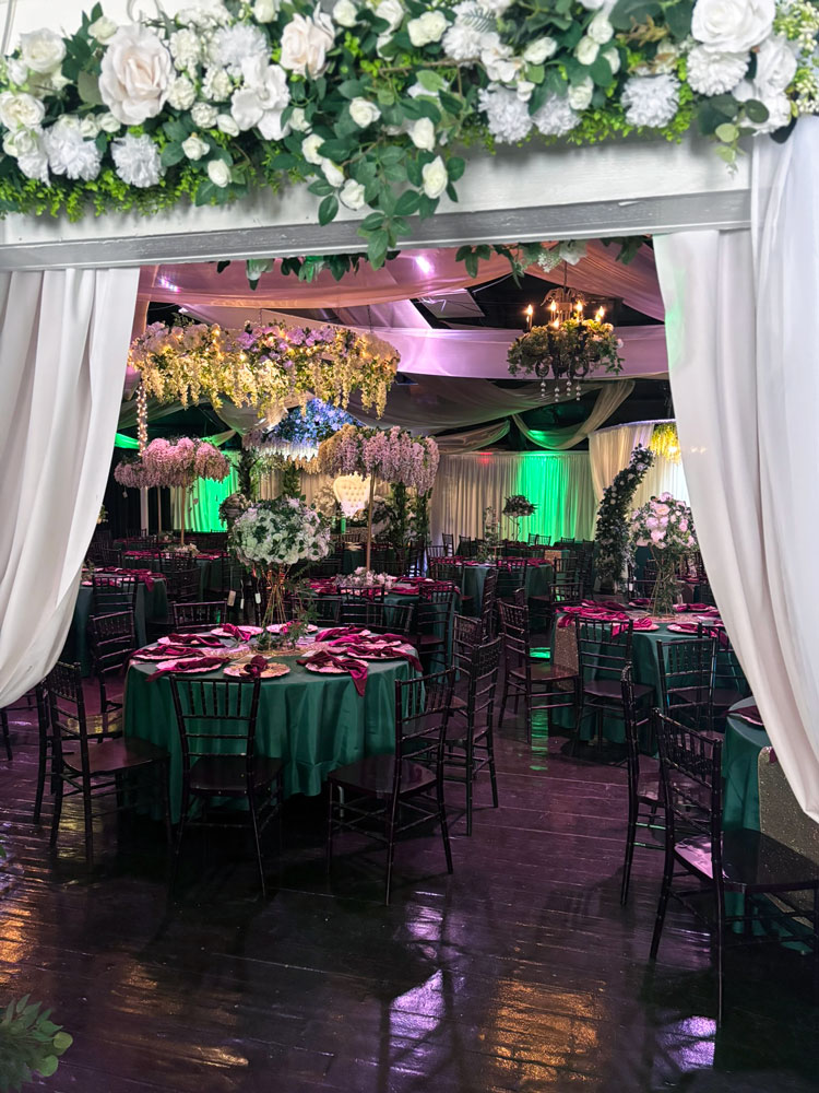 Entrance into the spacious wedding ballroom featuring green uplighting and neutral accents