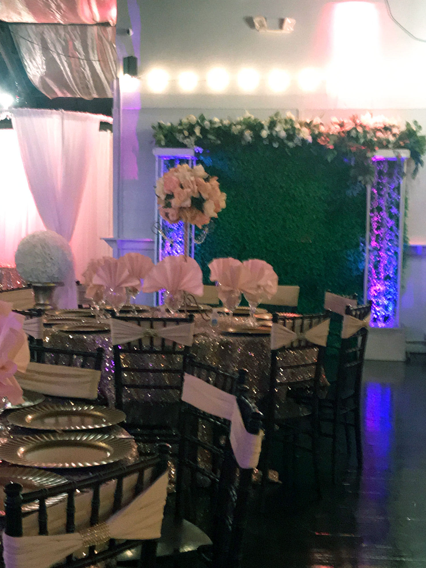 Elegant ballroom decorated in soft shades of pink with uplighting and floral accents