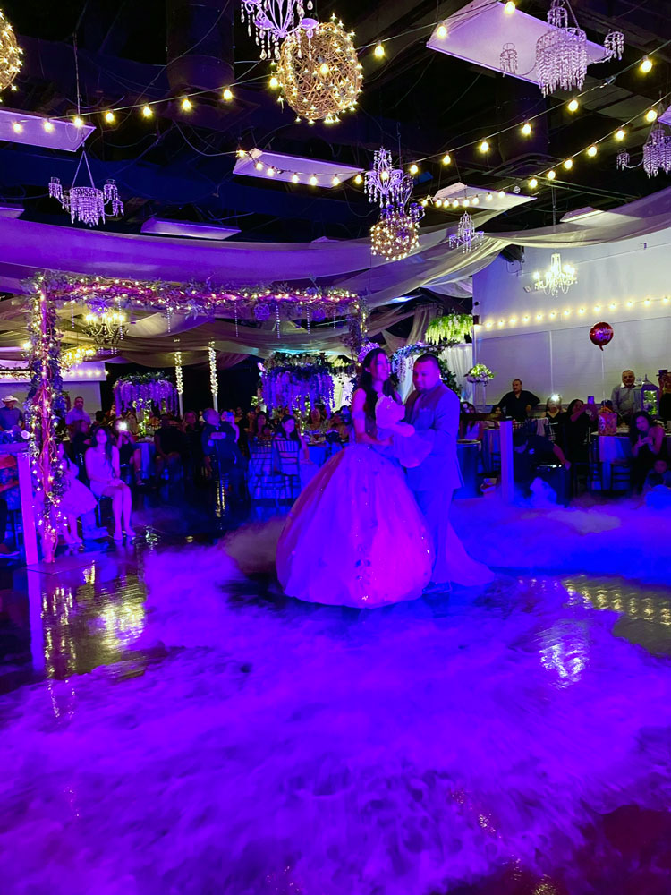 Ballroom dance floor accented with soft violet lighting and dramatic ambiance
