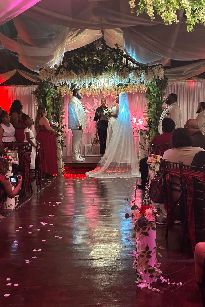 Wedding couple exchanging vows beneath a garden gazebo at a romantic wedding venue