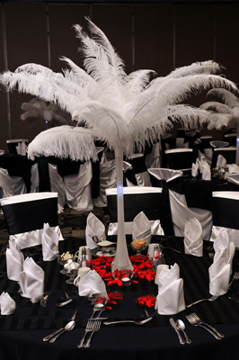 Tall ostrich feather centerpiece guest tables that's ready for guests.