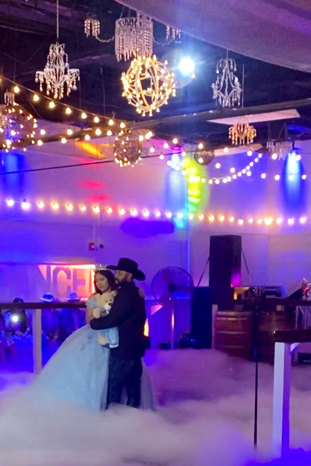 Quinceañera girl with father preparing for a first dance under the accent lights and on a shiny dance floor