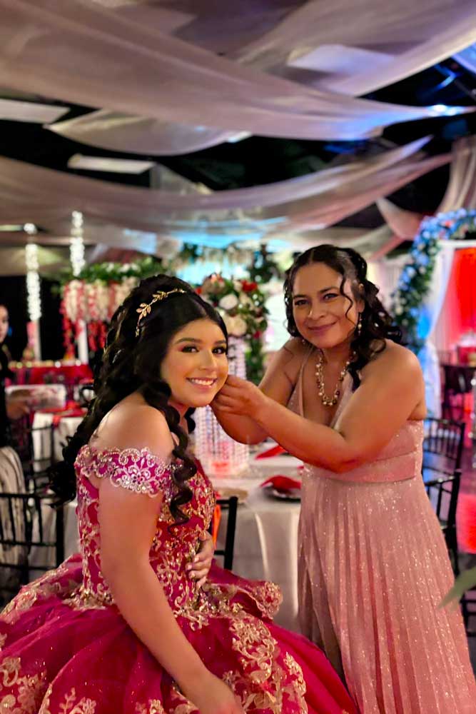 Quinceañera girl with Mom getting the daughters earrings just right..