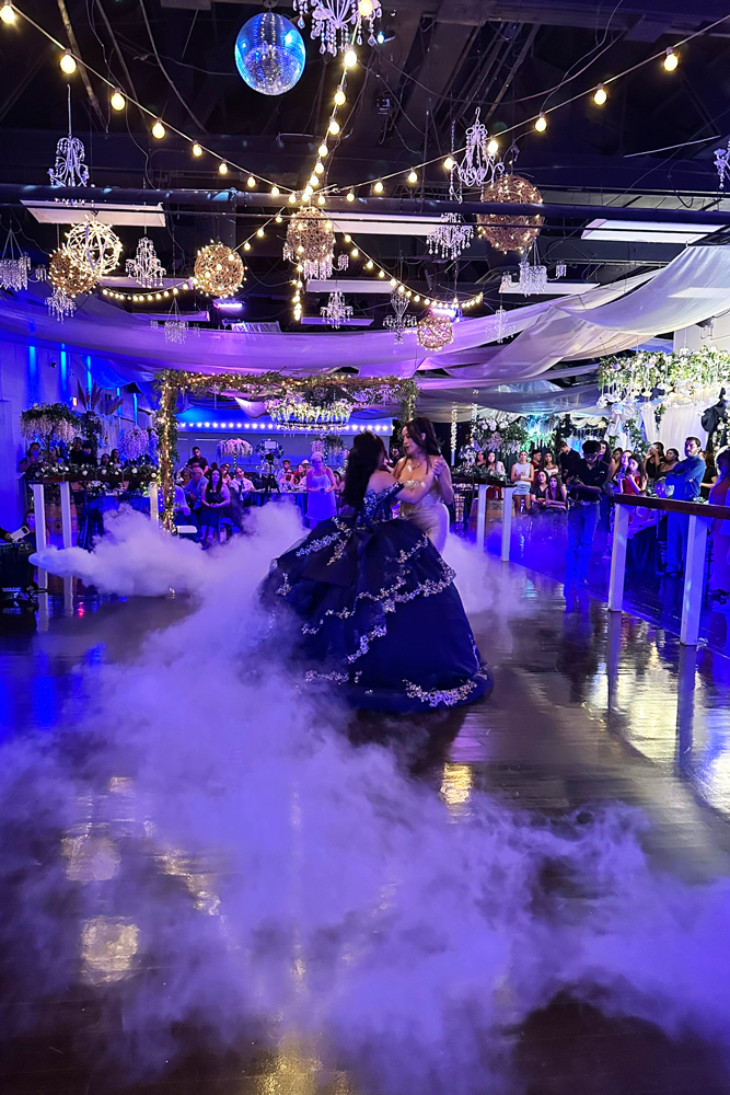 Quinceanera girl on illuminated dance floor with Mother during celebration dance.