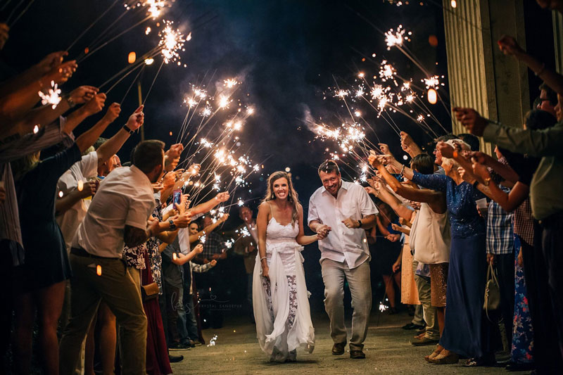 Bride and groom farewell under portaco with lights sparkler exit.