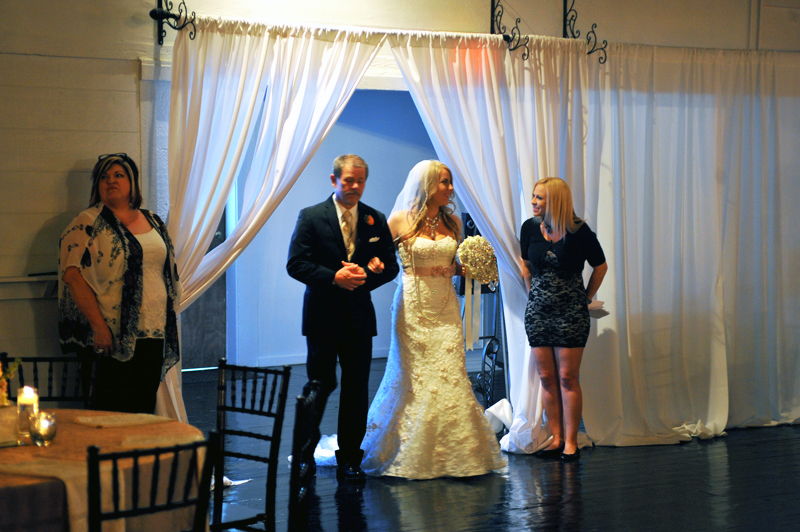 Bride with father making her walk toward the ceremony garden gazebo.