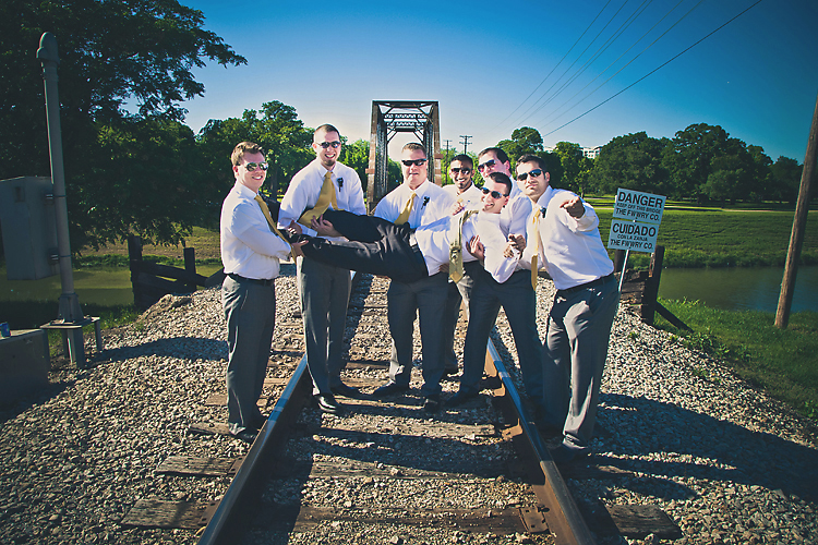 Groomsmen having fun enjoying the festivities on the railroad tracks with the groom.