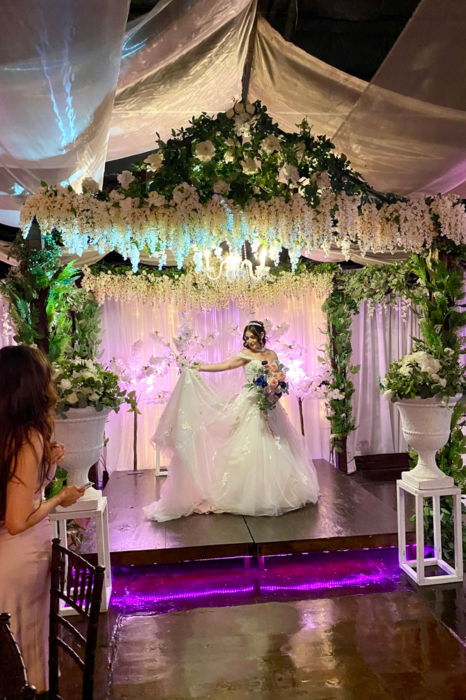 Bride posing for wedding photos after the ceremony in the garden gazebo.