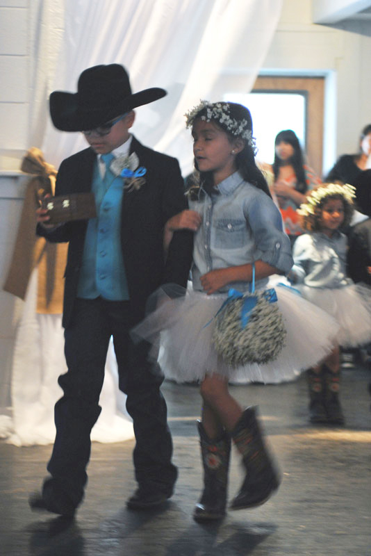 Ring bearer and flower girl making an entrance as they head toward.