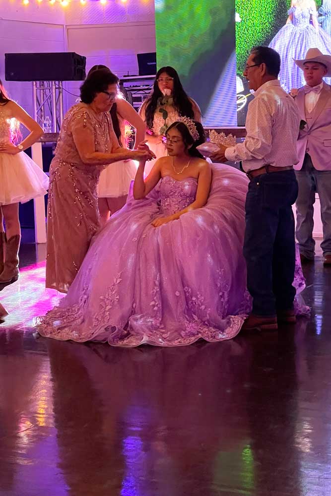 Quince girl with family - moment to receive her tiara on dance floor.