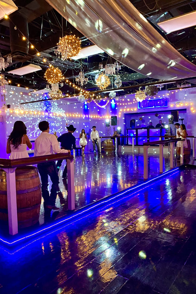 Guests dancing on a beautifully lit dance floor during a lively party