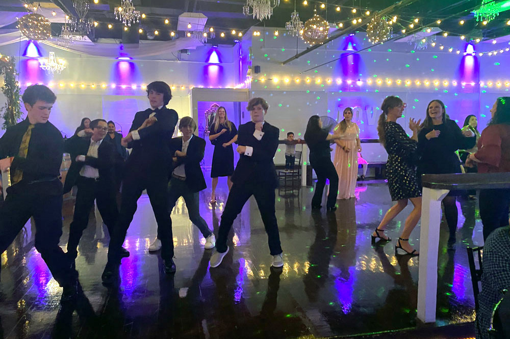 Guests dancing under colorful lights on a lively dance floor