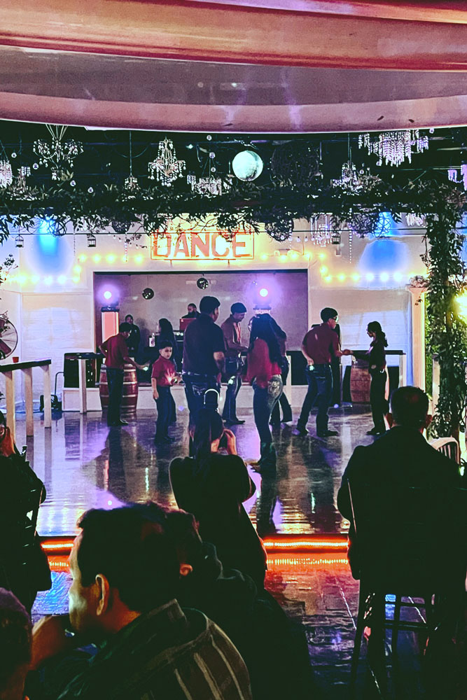 Crowded dance floor with colorful uplighting for party energy