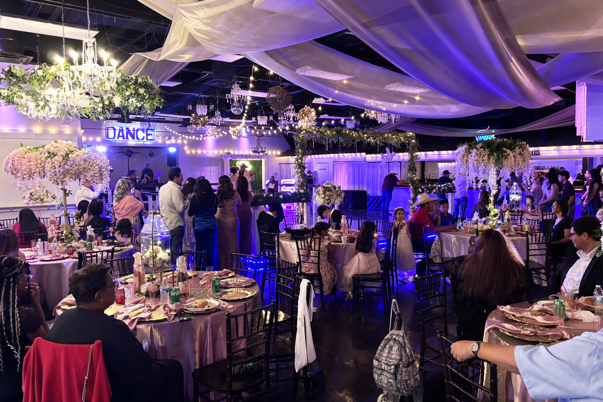 Guest arrival greeting the quince girl in front of the garden cake table.