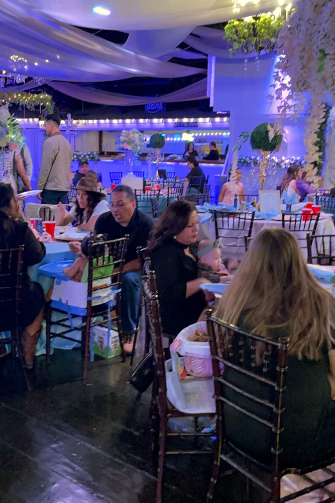 Guests enjoying our beautiful and well lit ballrooom with accent lighting and guest tables that are already set up.
