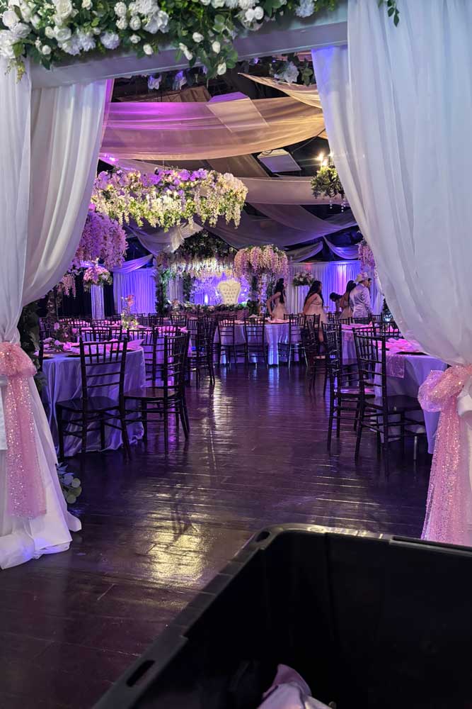 Decorated room at a corporate event with tall centerpieces and decorative lighting