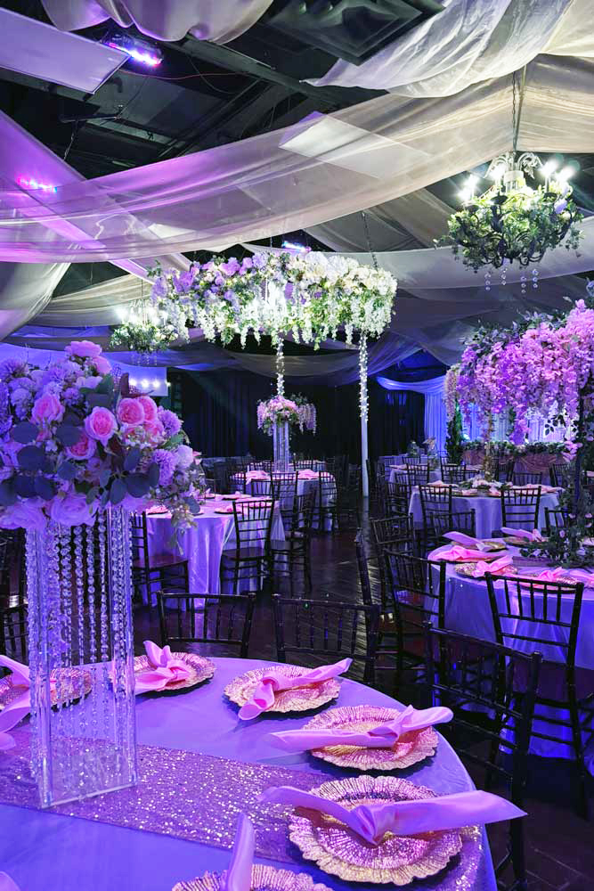 Table of honor with fabric, roses, and bows background.